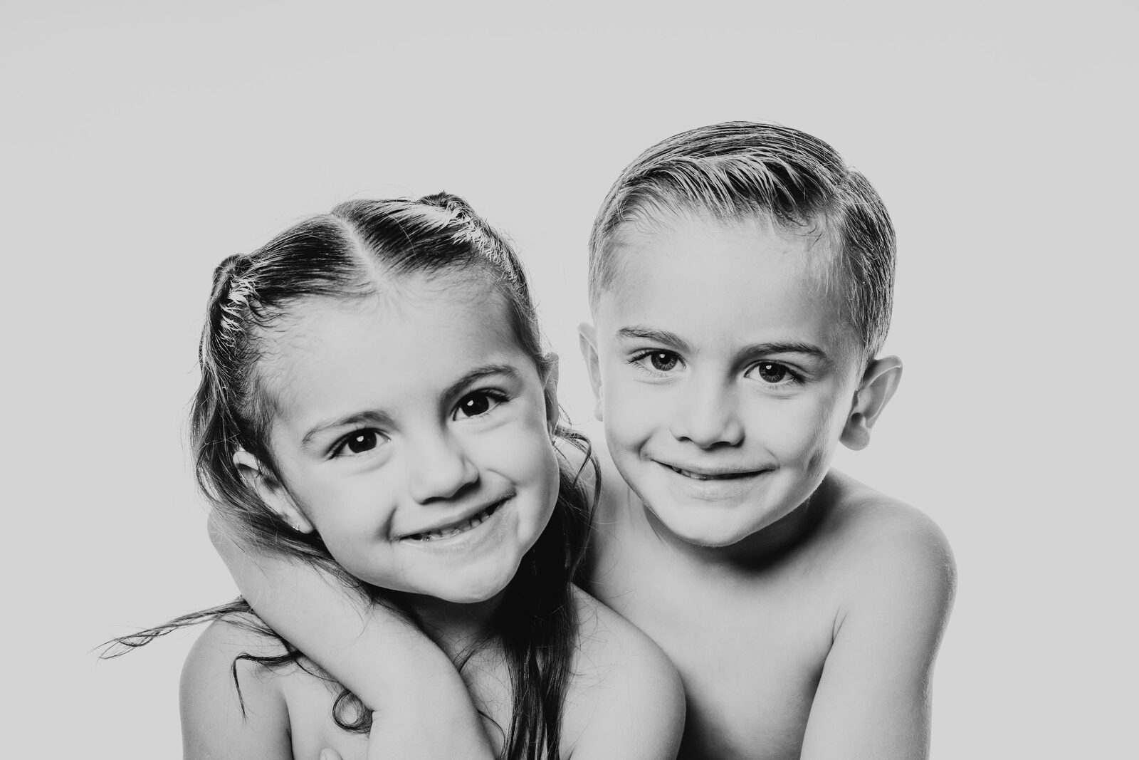 Dos hermanos abrazados en su sesión de familia