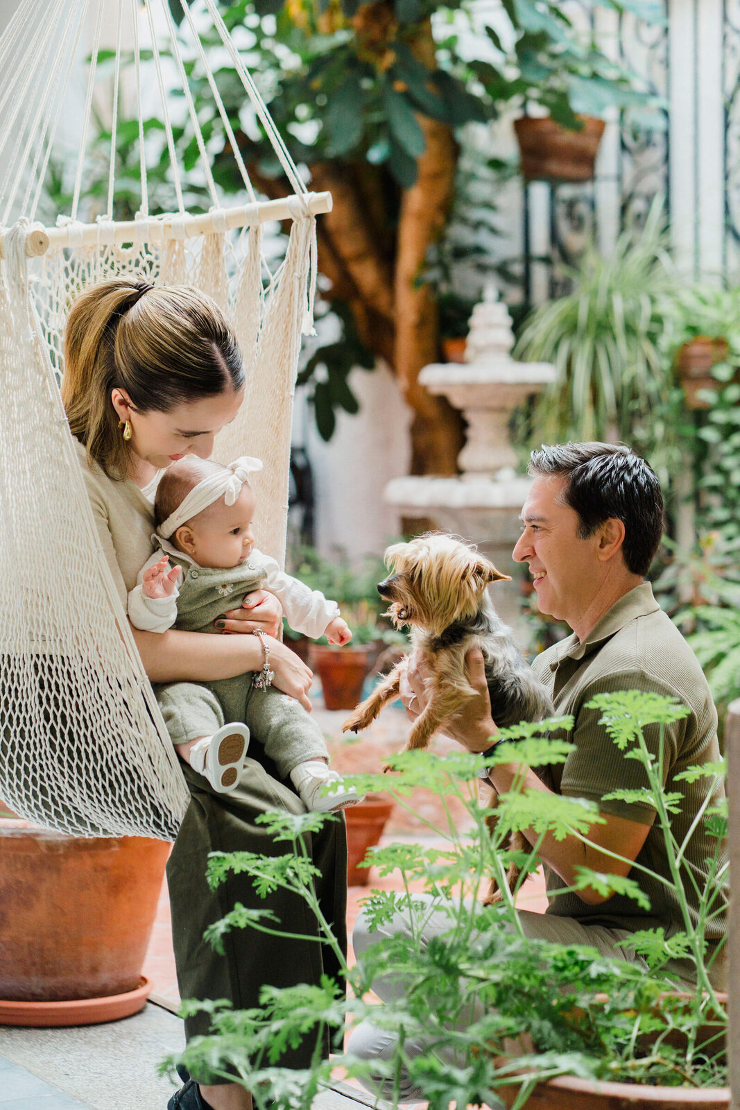 Familia con su perrito en un jardín durante la sesión