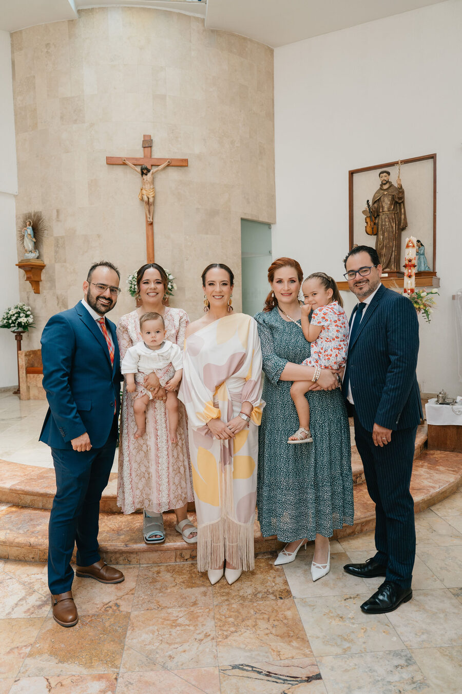 Familia y padrinos junto al altar después de la ceremonia