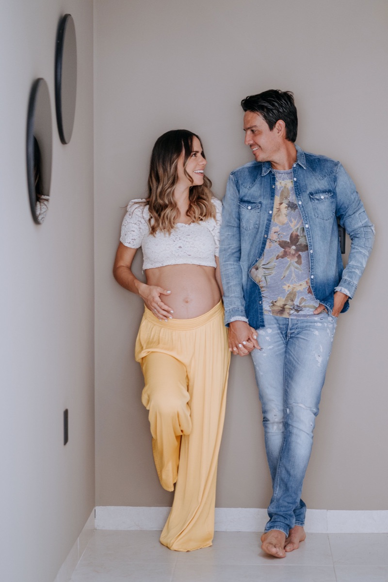 Pareja en rincón de casa, mamá con vestido amarillo