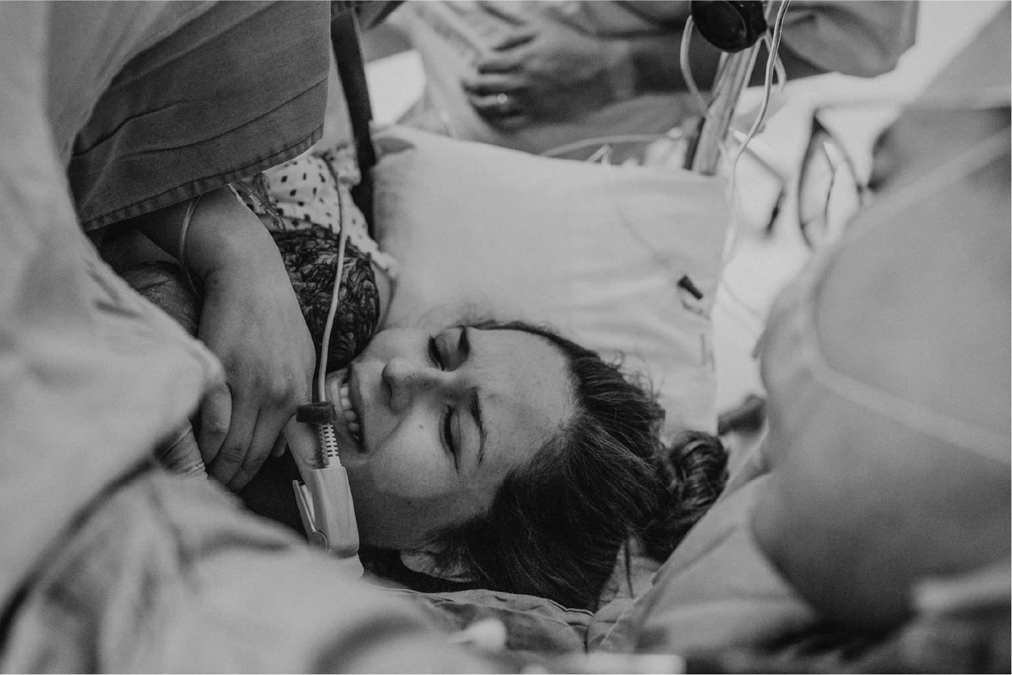 Mamá descansando con los ojos cerrados justo después del nacimiento, fotografía en blanco y negro